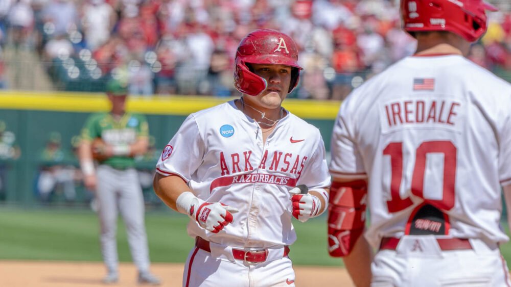 Razorbacks' Cam Kozeal finishing after homer in an NCAA Regional game against North Dakota State