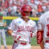 Razorbacks' Cam Kozeal finishing after homer in an NCAA Regional game against North Dakota State