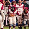Arkansas softball players wait at home plate to celebrate Kailey Wyckoff's second-inning home run against Nebraska at the Women's College World Series. | Arkansas Communications
