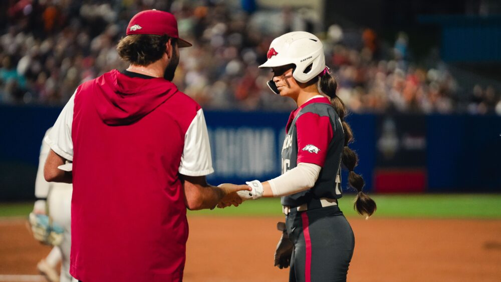 Arkansas senior Kylie Wyckoff talks with an Arkansas assistant coach during a WCWS game against UCLA. | Arkansas Communications
