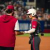 Arkansas senior Kylie Wyckoff talks with an Arkansas assistant coach during a WCWS game against UCLA. | Arkansas Communications