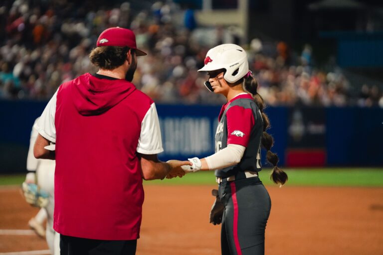 Arkansas senior Kylie Wyckoff talks with an Arkansas assistant coach during a WCWS game against UCLA. | Arkansas Communications
