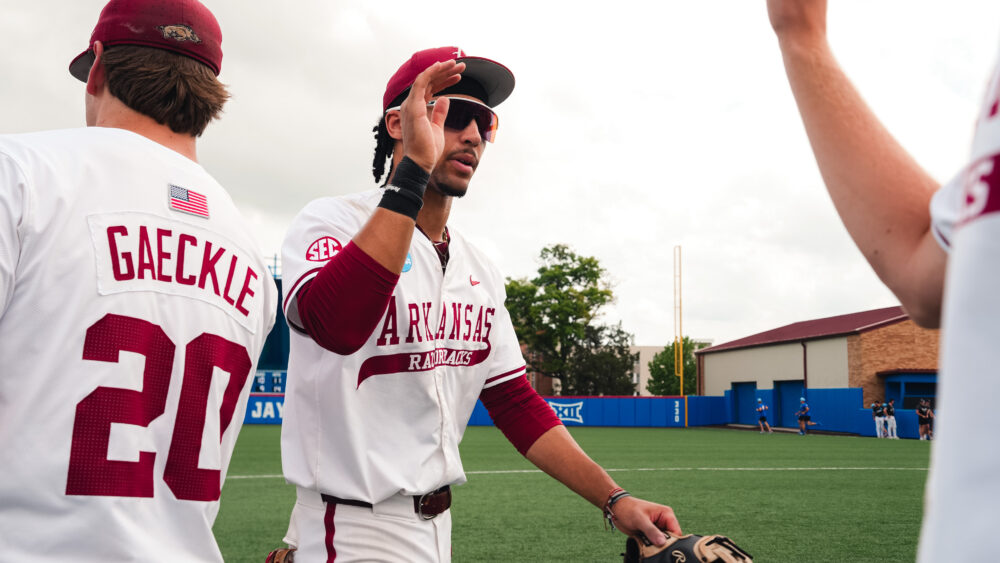 Arkansas junior TJ Pompey high fives teammates after a elimination game victory against Northeastern. | Arkansas Communications