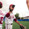 Arkansas junior TJ Pompey high fives teammates after a elimination game victory against Northeastern. | Arkansas Communications