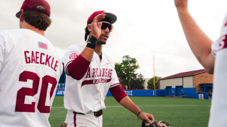 Arkansas junior TJ Pompey high fives teammates after a elimination game victory against Northeastern. | Arkansas Communications