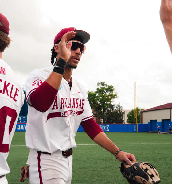 Arkansas junior TJ Pompey high fives teammates after a elimination game victory against Northeastern. | Arkansas Communications