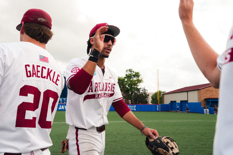 Arkansas junior TJ Pompey high fives teammates after a elimination game victory against Northeastern. | Arkansas Communications