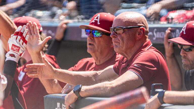 Arkansas baseball coaches discuss strategy from the dugout of a SEC game against Ole Miss in Fayetteville. | Nilsen Roman-allHogs Images