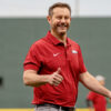 Arkansas Razorbacks coach Ryan Silverfield throwing out the first pitch at a baseball game.