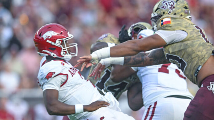 Arkansas Razorbacks quaterback KJ Jackson takes a hit from Texas A&M Aggies defensive end Marco Jones